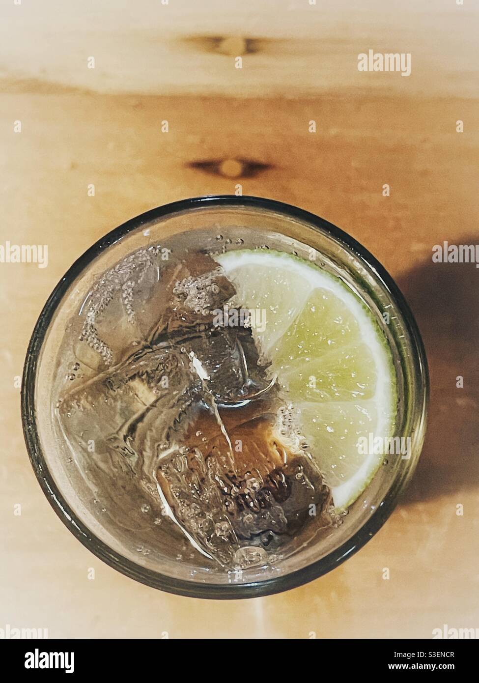 Overhead view of a gin and tonic cocktail on a wooden table - Smartphone Captured Stock Image