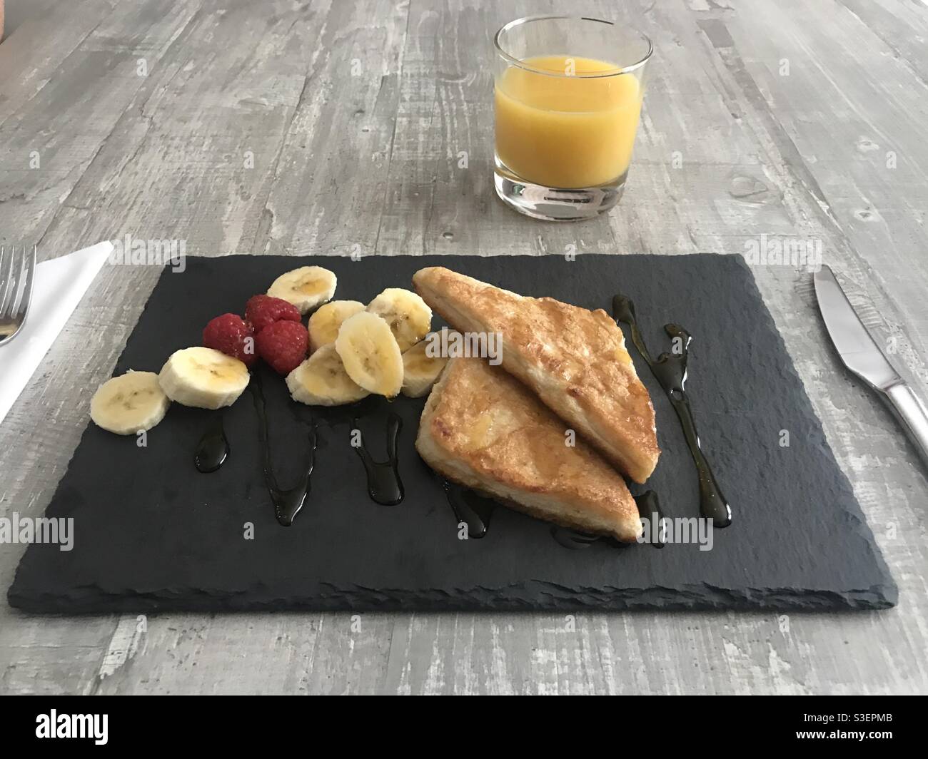 Cinnamon French toast served with raspberries and sliced bananas and drizzled with maple syrup - Smartphone Captured Stock Image