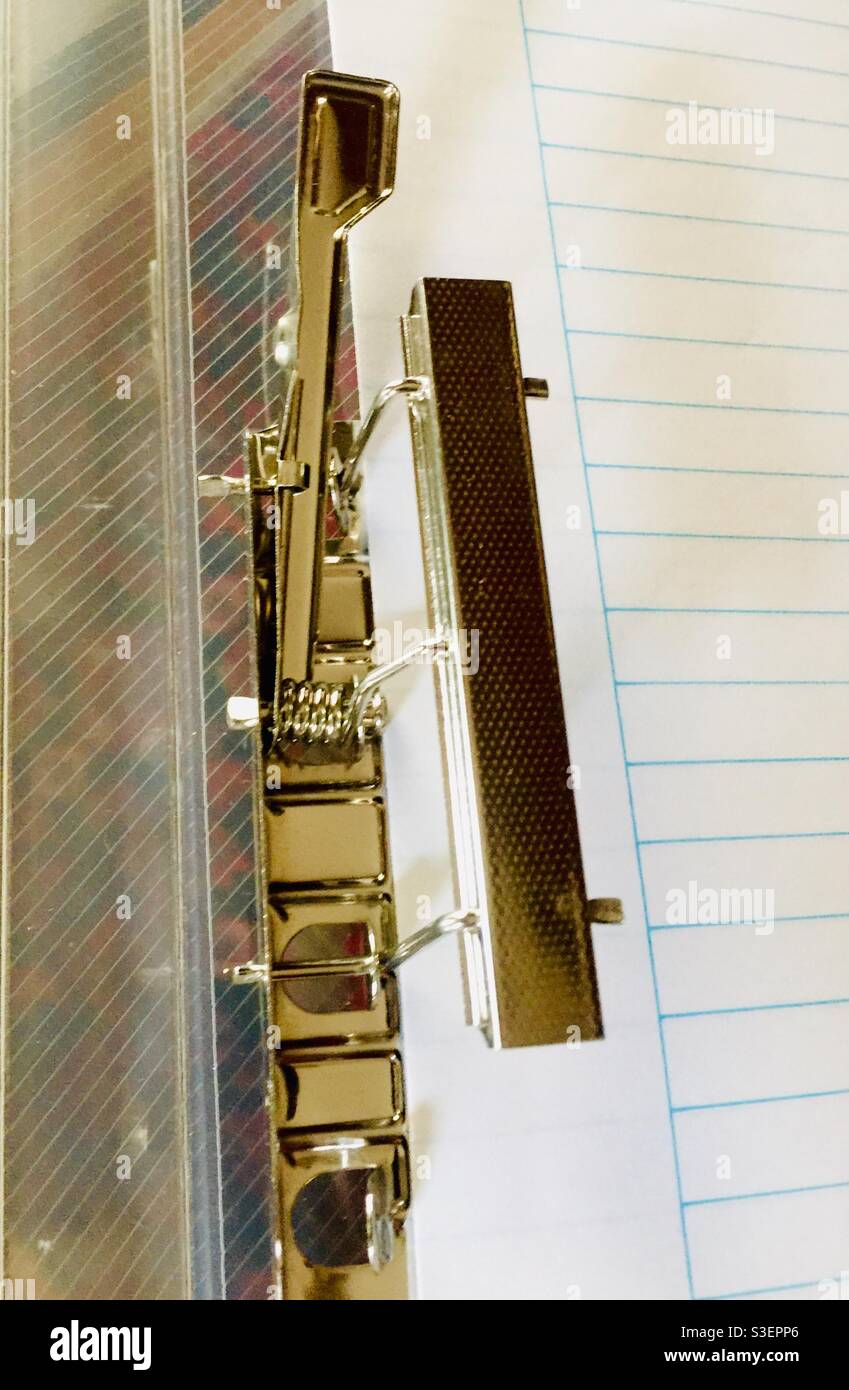 Old-style paper clamp with a lever. Elegant, one-step operation. Simple, effective. Concepts: simplicity, efficiency, best in class. - Smartphone Captured Stock Image