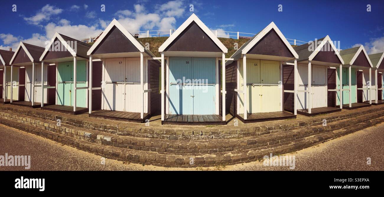 Panoramic view of rows of colourful beach huts at an old fashioned British seaside resort with copy space - Smartphone Captured Stock Image