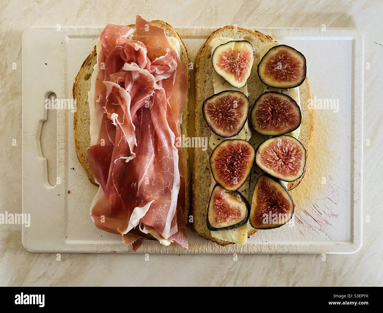 Toasted Brie, Parma Ham and Fig Samdwich being prepared on a chopping board. - Smartphone Captured Stock Image