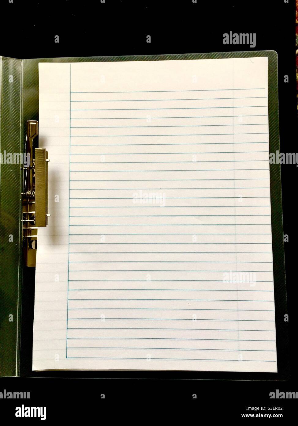 A binder with a classic metal clasp, hovering over a sheaf of blank sheets. Concepts: starting over, back to basics, square one, new beginning. - Smartphone Captured Stock Image