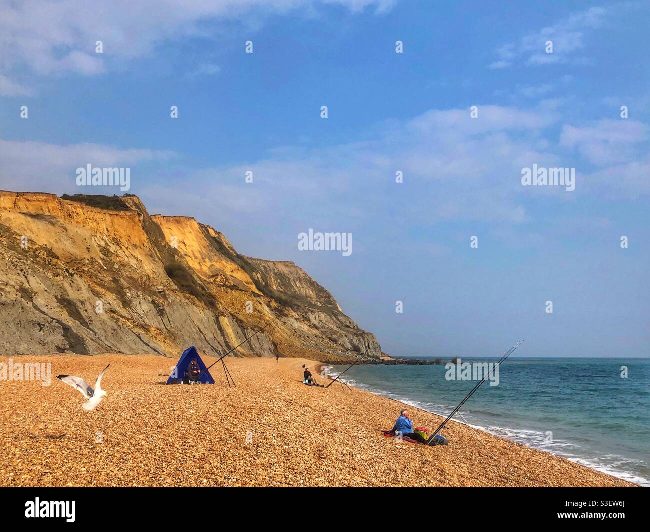 Fishermen on Seatown beach Jurassic coast, Dorset with cliff in the background which collapsed in April 2021 - Smartphone Captured Stock Image