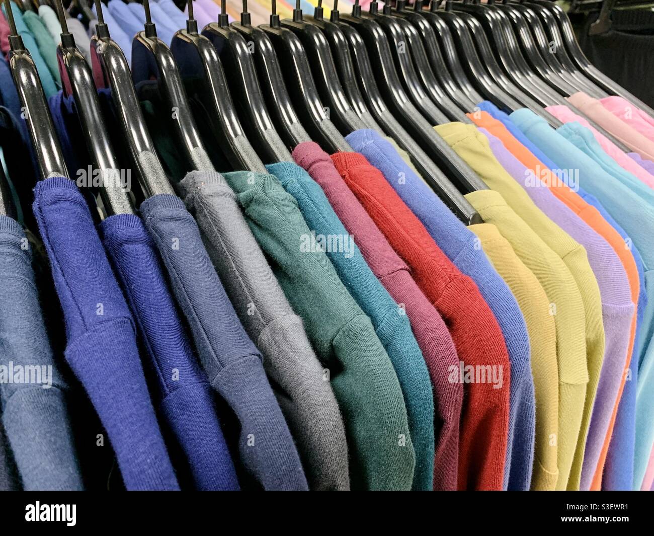 Colorful clothing hanging on hanger rack Stock Photo - Alamy