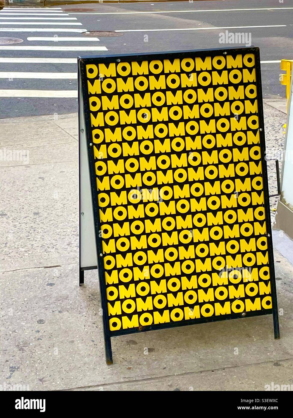 Yellow and black sidewalk sign in New York City - Smartphone Captured Stock Image