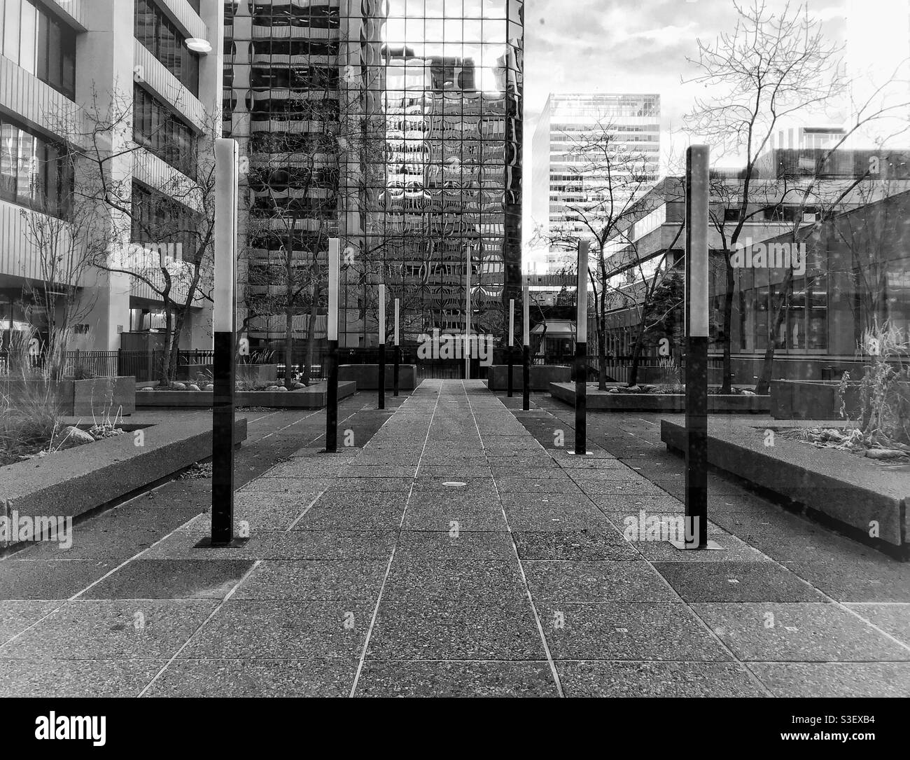 Looking out from the Calgary Plus15 walkway, to a deserted seating area and office buildings all around. Downtown Calgary, Alberta, Canada. - Smartphone Captured Stock Image
