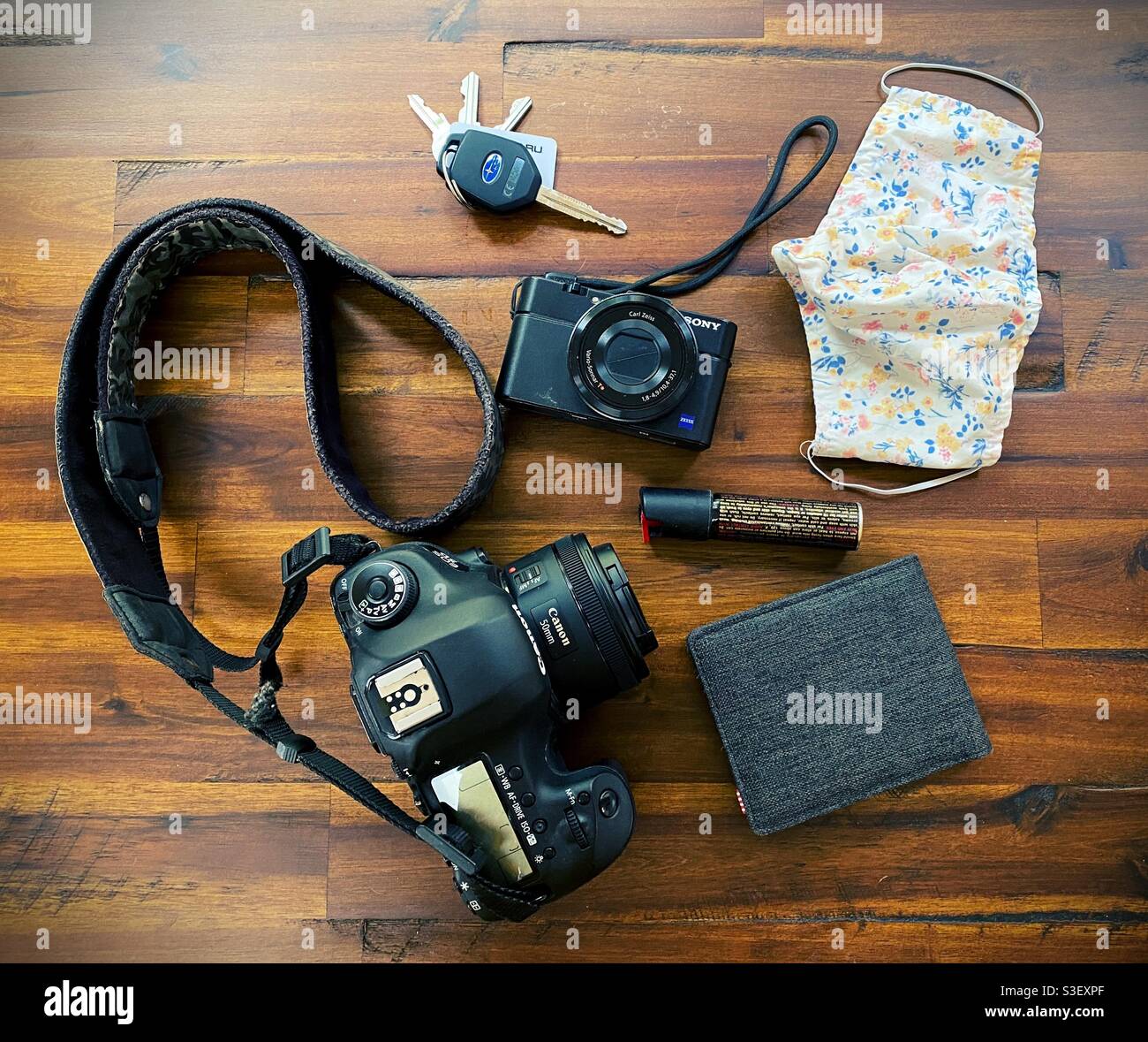 Top down view of a street photogrspher's gear, including two kinds of cameras, keys, face mask, wallet, and pepper spray. Stock Photo