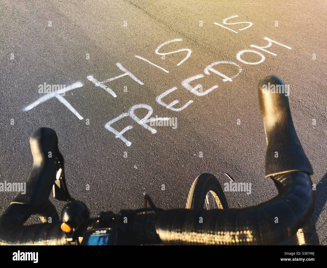 The Words this is Freedom Viewed over the Drop Bars of a Bicycle on the Pavement Stock Photo