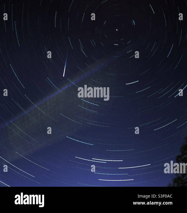 Star trails, a meteor and a wispy cloud in the night sky. - Smartphone Captured Stock Image