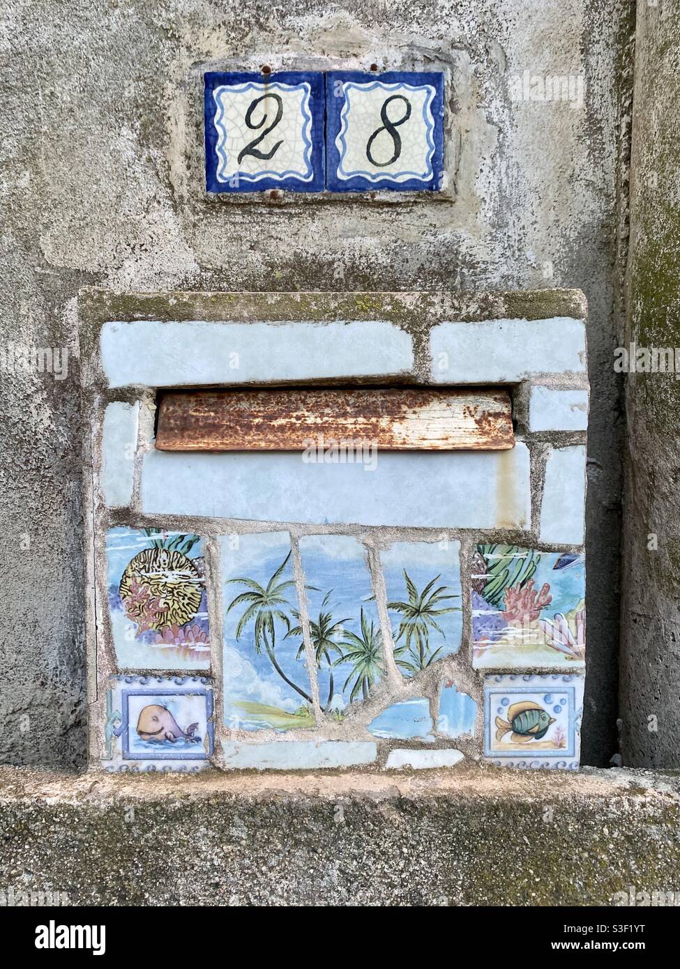 Beautiful rusty painted landscape with palm trees on a mailbox with number 28, south of France - Smartphone Captured Stock Image