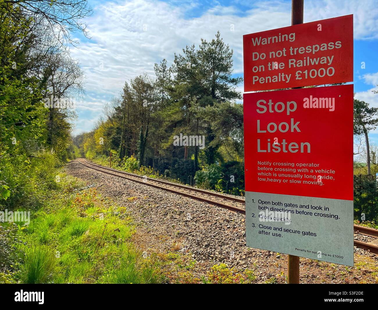 Warning notice alongside a single track railway line through countryside - Smartphone Captured Stock Image