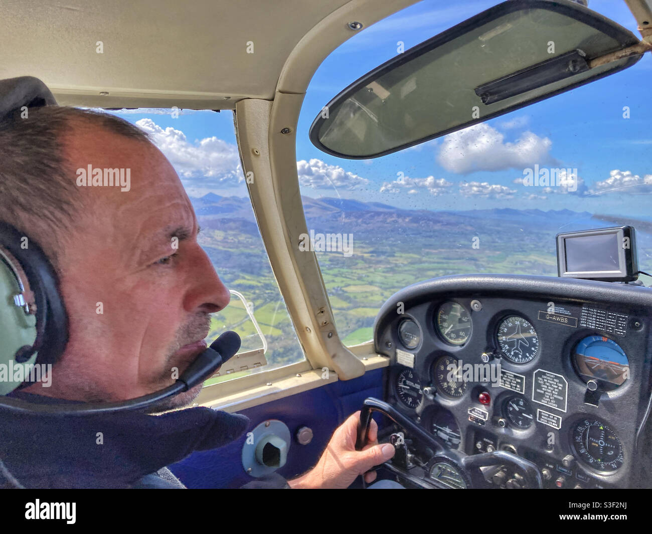 Pilot flying a Piper PA-28 Cherokee Cruiser in Snowdonia Wales Stock Photo