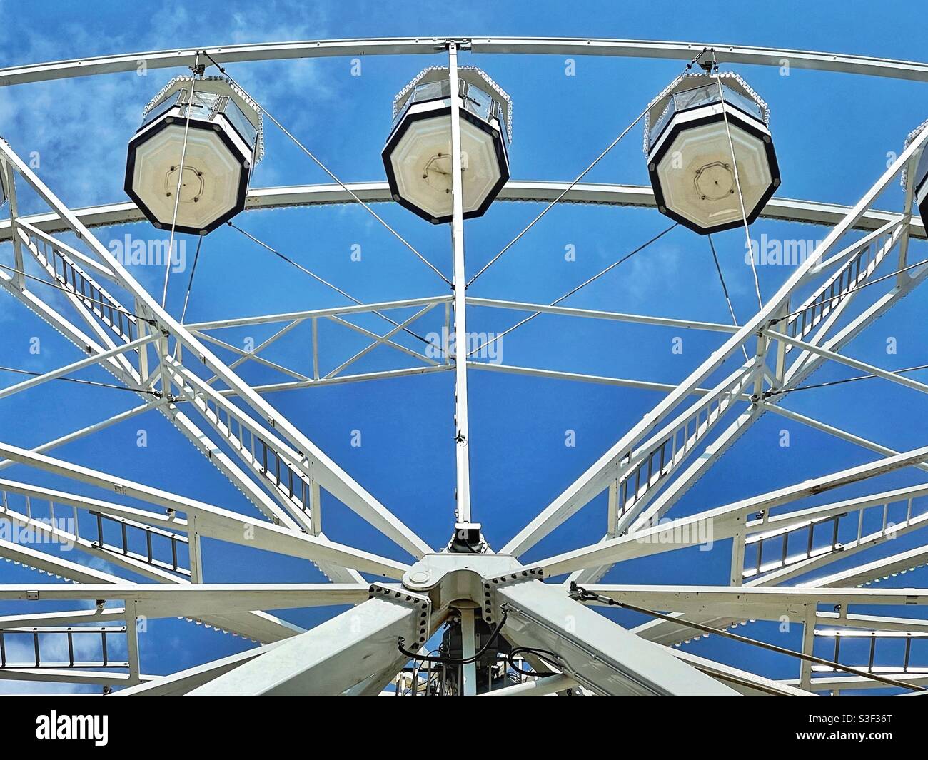 Capsules on the top of a giant Ferris wheel against a deep blue sky. No people. Stock Photo