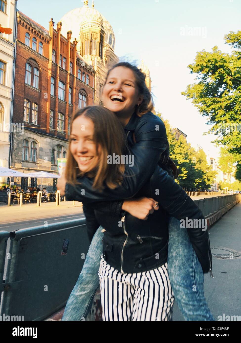 Girls piggybacking and laughing Stock Photo