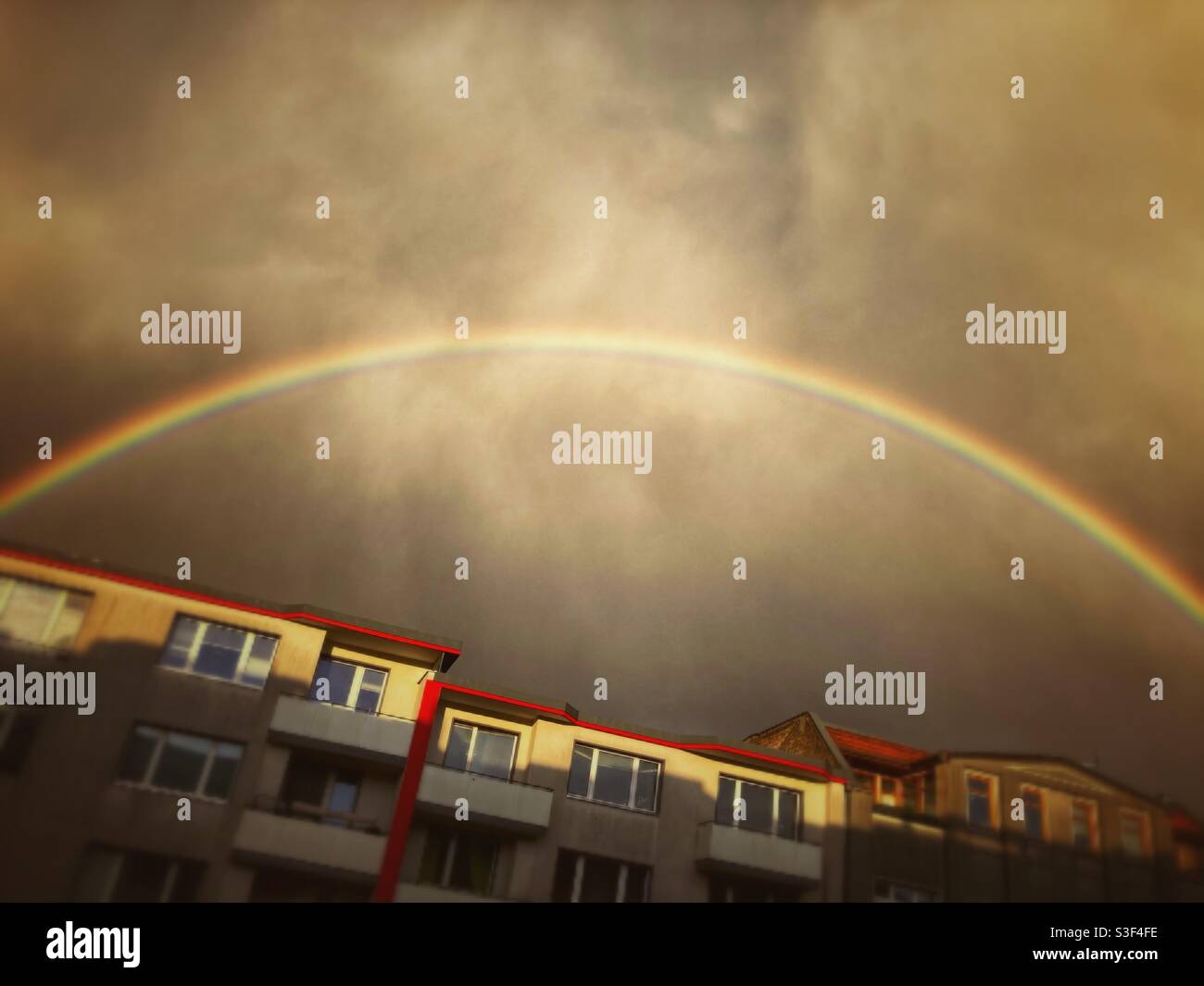 A dramatic Rainbow over the roofs of houses in Kreuzberg, Berlin, Germany - Smartphone Captured Stock Image A dramatic Rainbow over the roofs of houses in Kreuzberg, Berlin, Germany - Smartphone Captured Stock Image