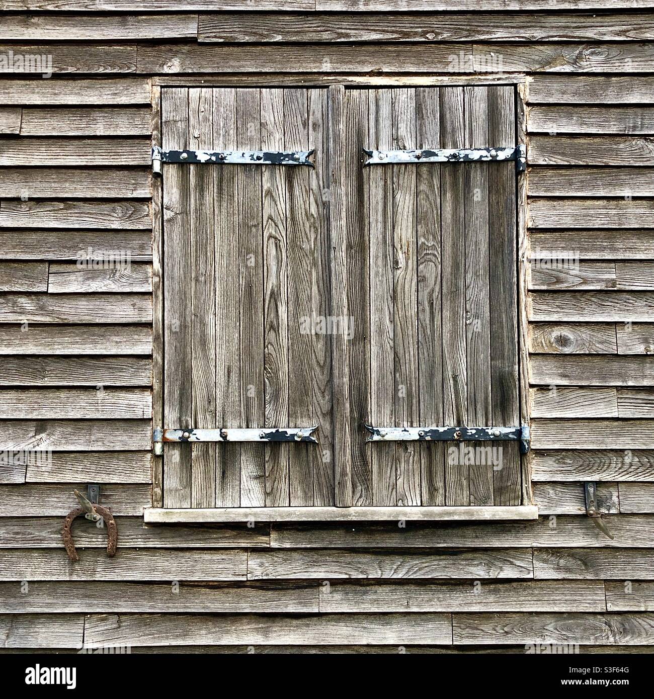 Old weathered wooden wall and window shutters. - Smartphone Captured Stock Image