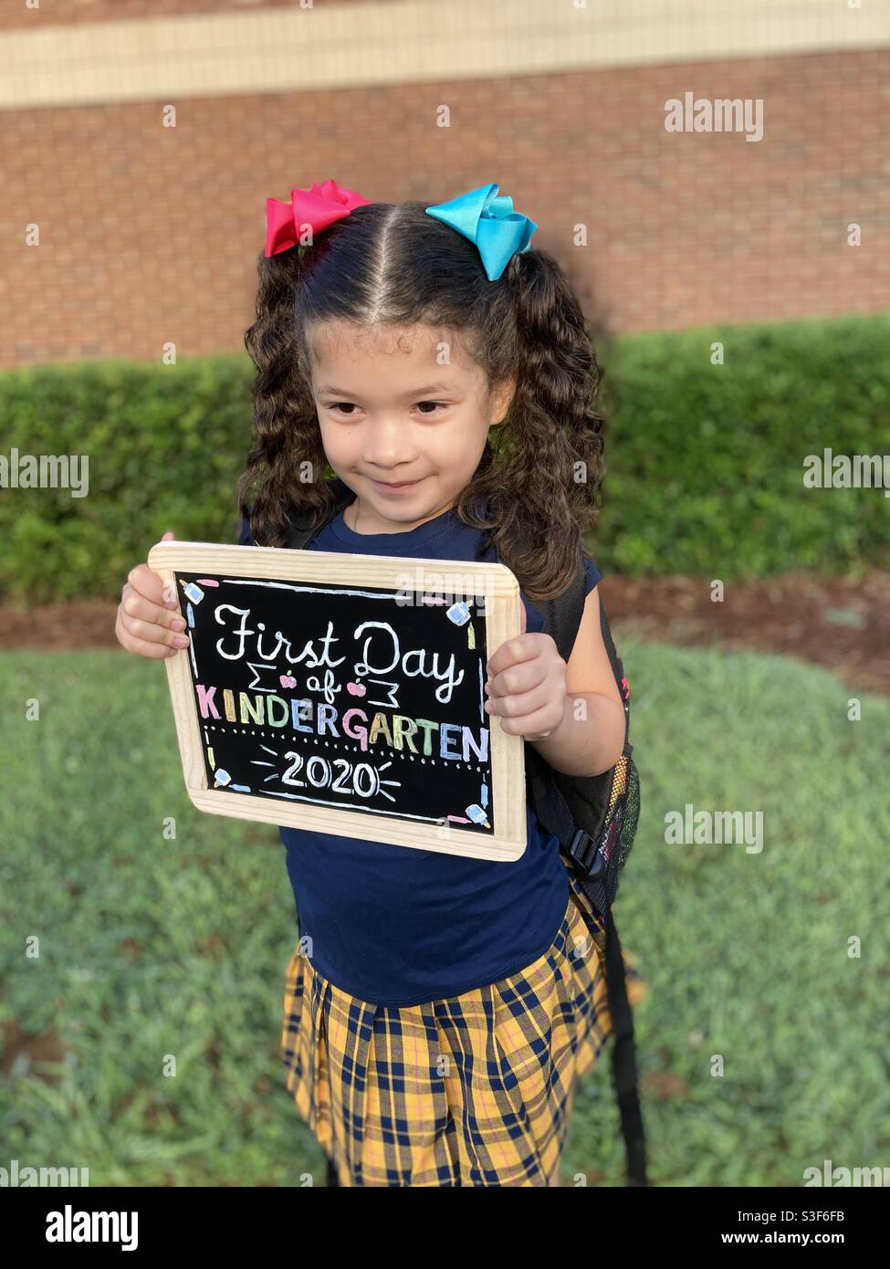 Little girl holding sign for first day of school photography Stock Photo