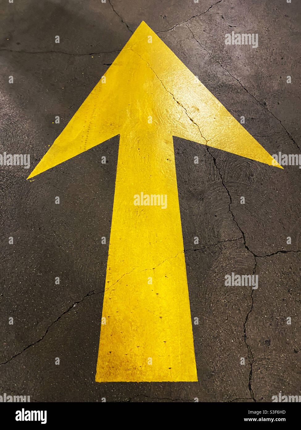 Yellow arrow pavement sign - Smartphone Captured Stock Image