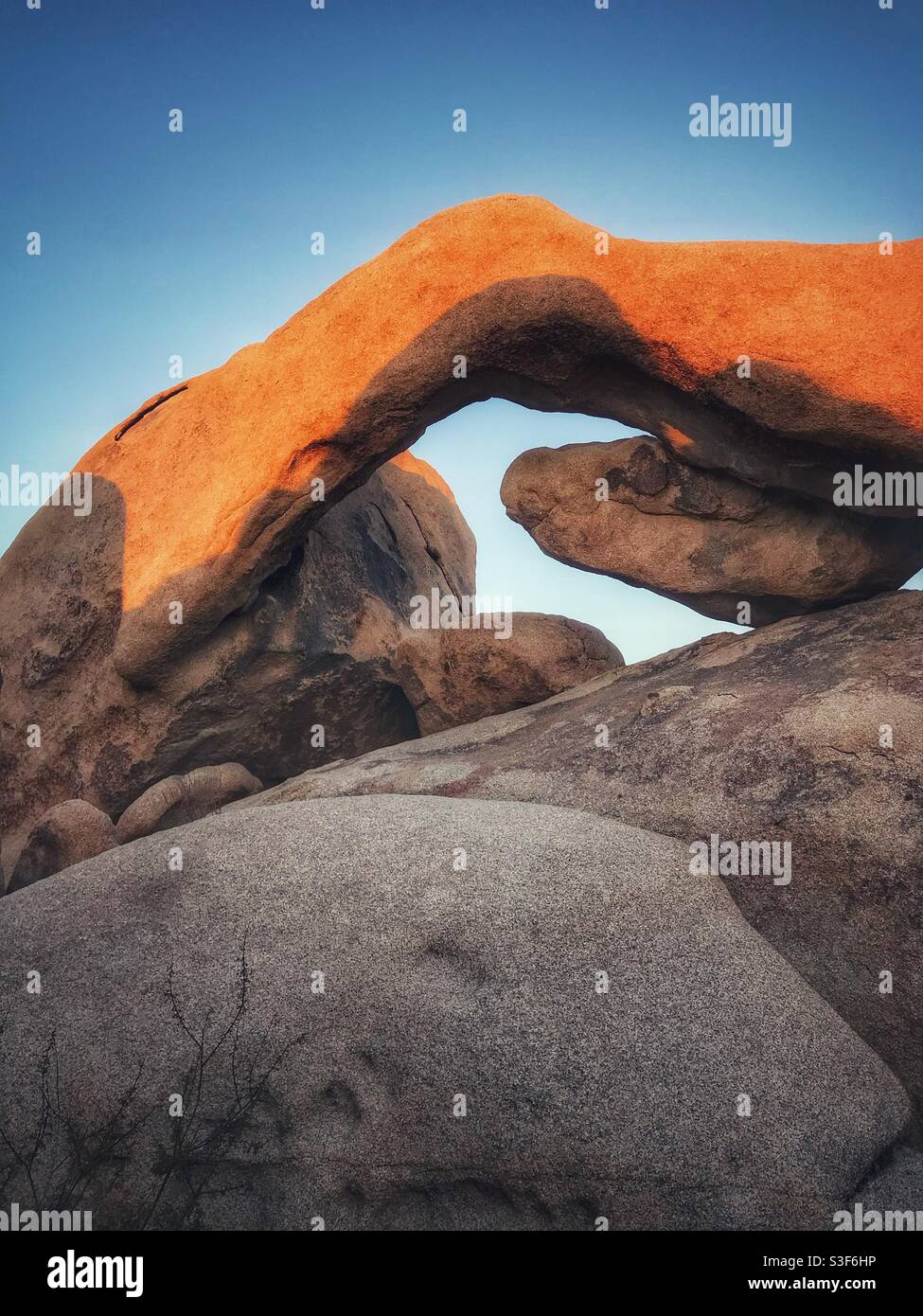 Vertical view of late afternoon shadows on Arch Rock, Joshua Tree National Park, California - Smartphone Captured Stock Image