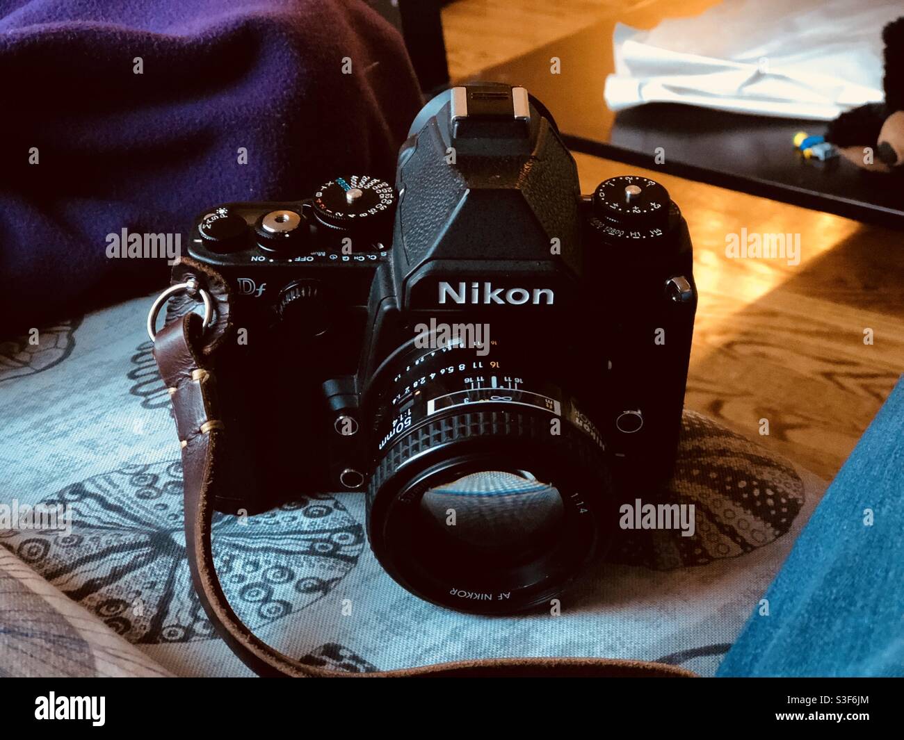 Nikon Df full frame DSLR digital camera with a Nikkor 50mm f1.4 vintage lens on a home background with wooden floor Stock Photo
