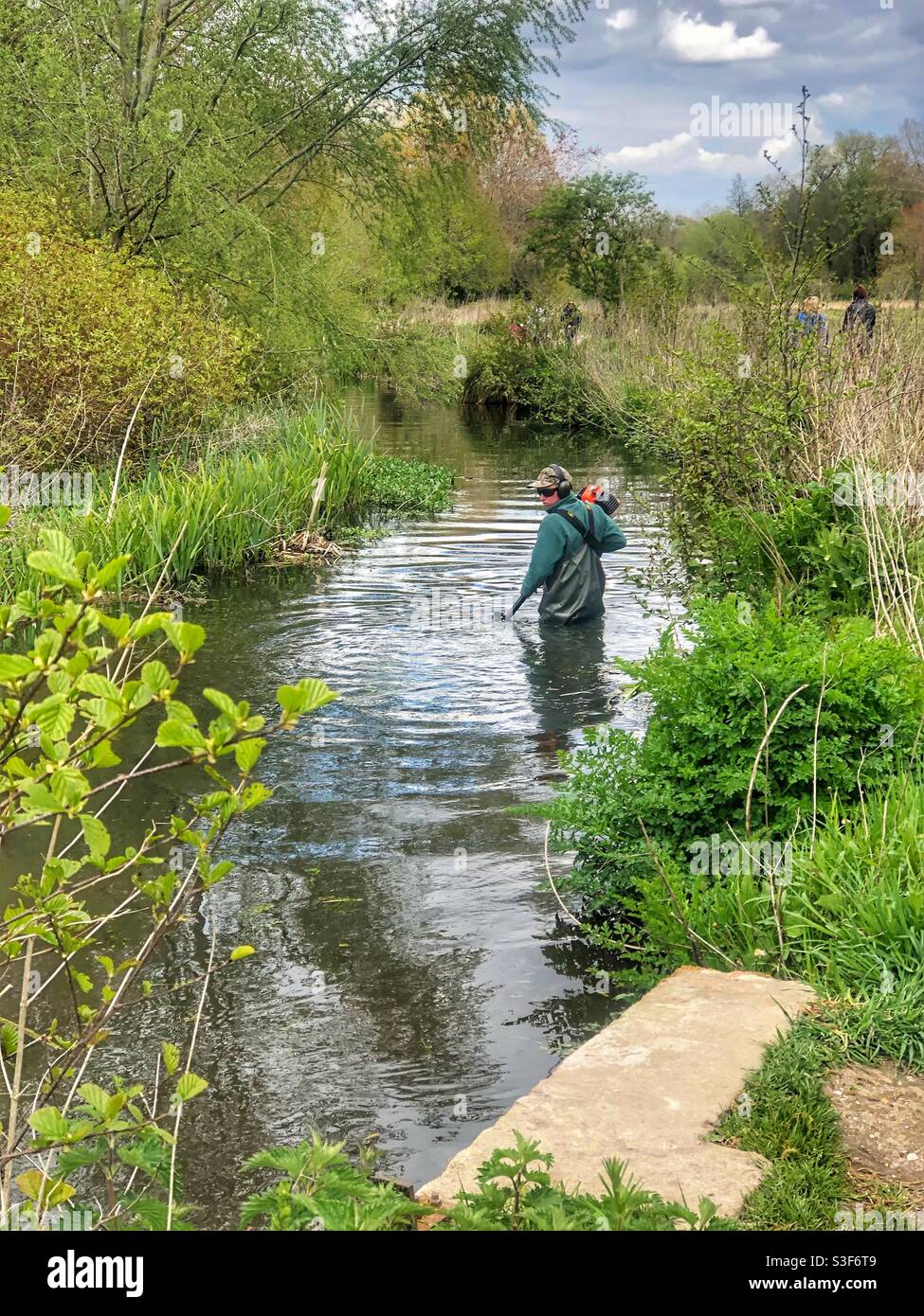 Cutting vegetation underwater in the River Itchen in Winchester Hampshire UK - Smartphone Captured Stock Image