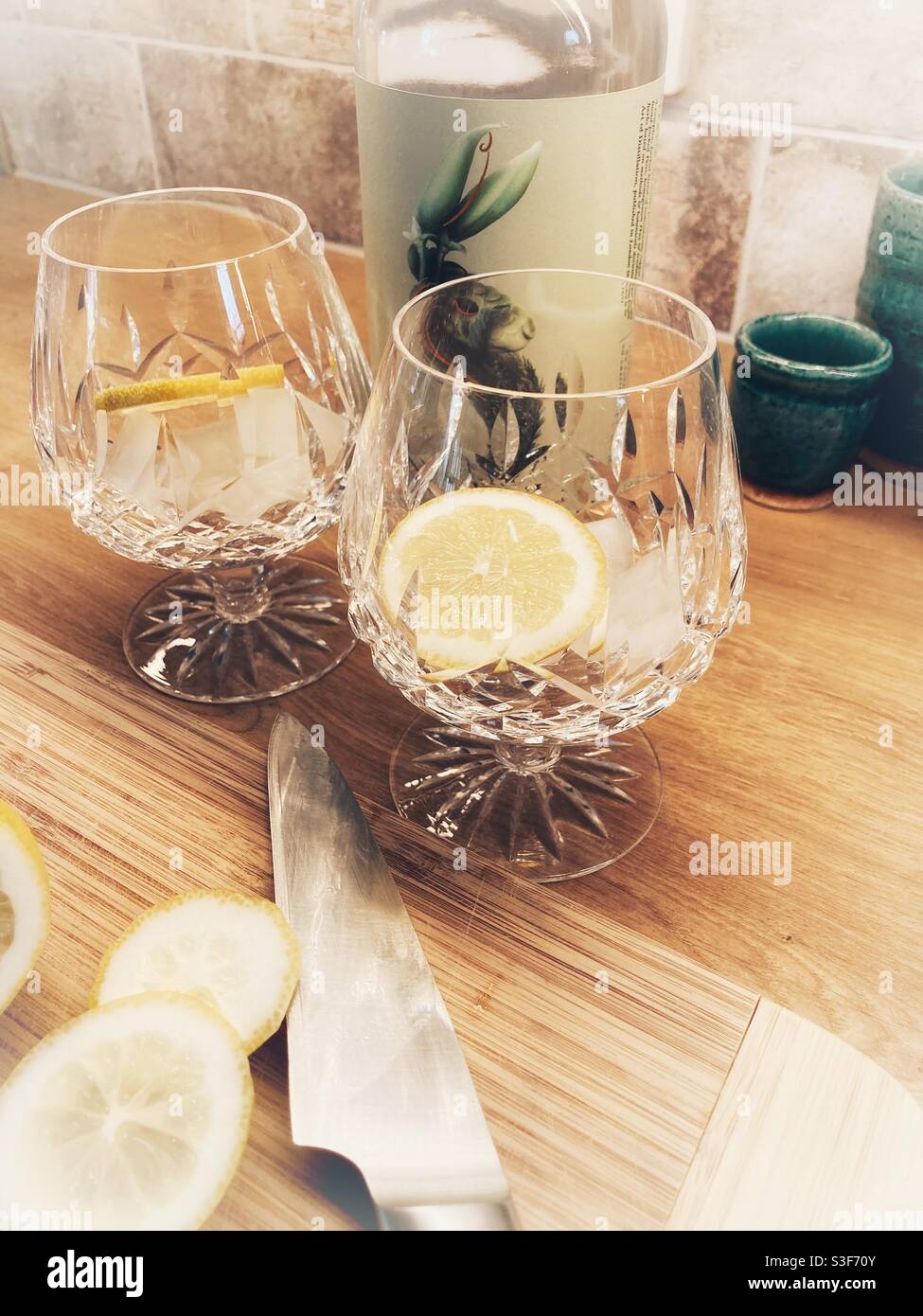Seedlip non alcoholic distilled spirit - lemon slices on a chopping board- gin and tonic Stock Photo