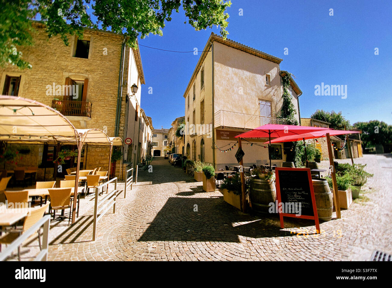 Restaurant terrasses in a small village street in the south of France, during the summer - Smartphone Captured Stock Image