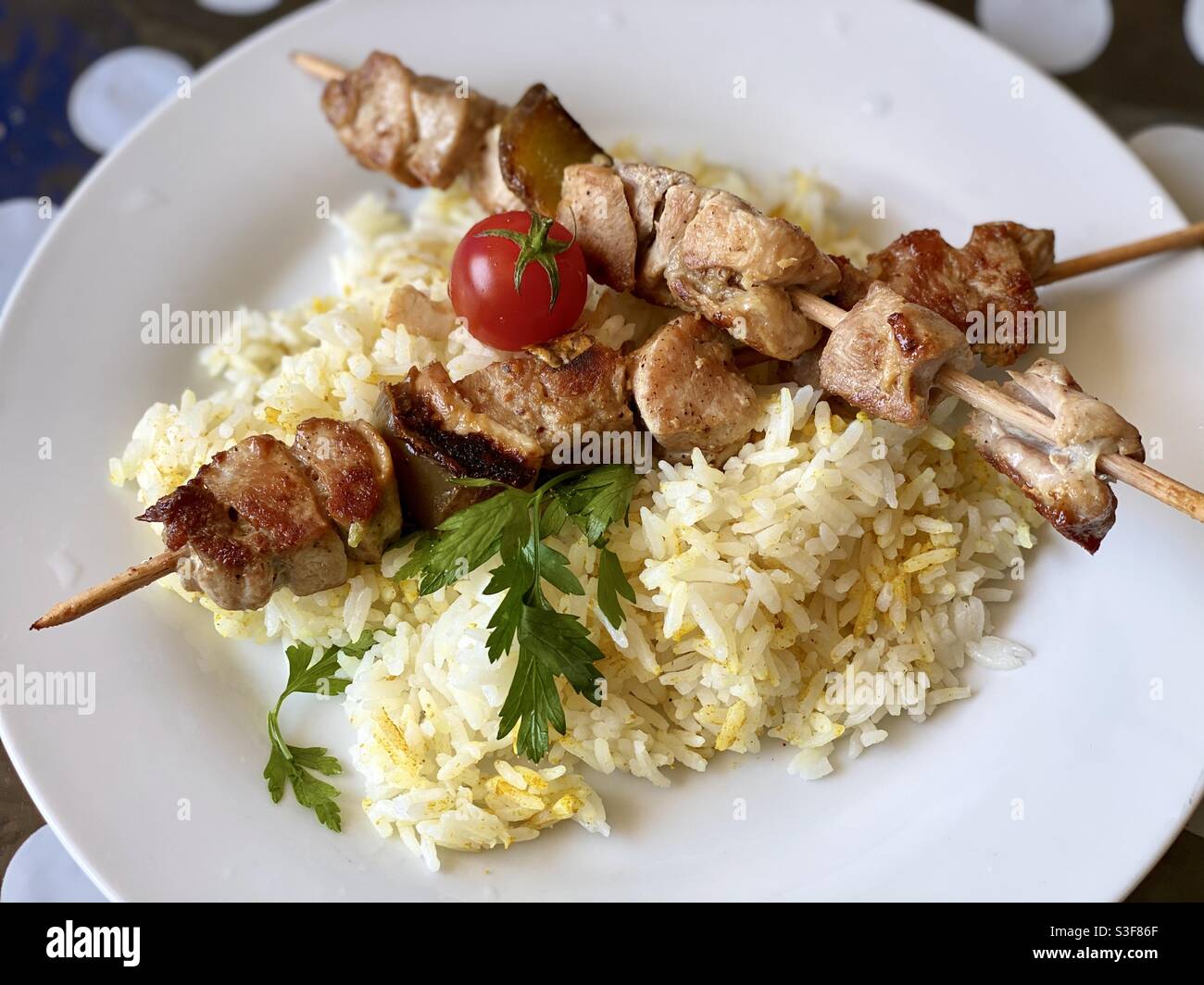 Pork skewers on rice with tomatoes Stock Photo