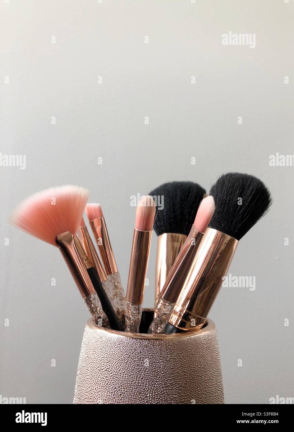 Makeup brushes in a shiny jar Stock Photo