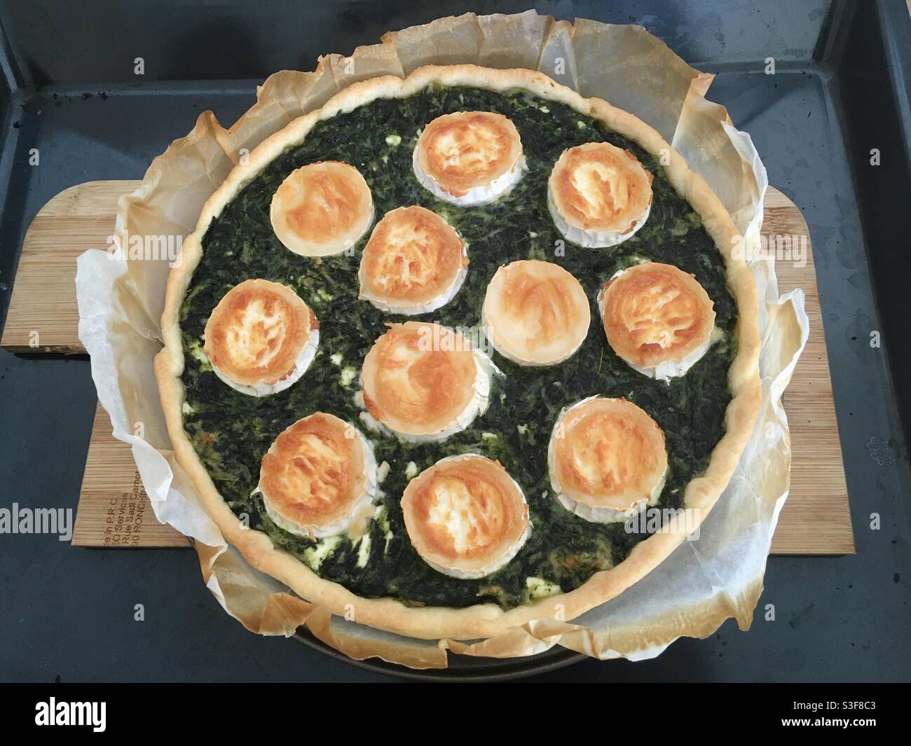 Homemade spinach omelette pie tart with goat cheese on a wooden plank - Smartphone Captured Stock Image