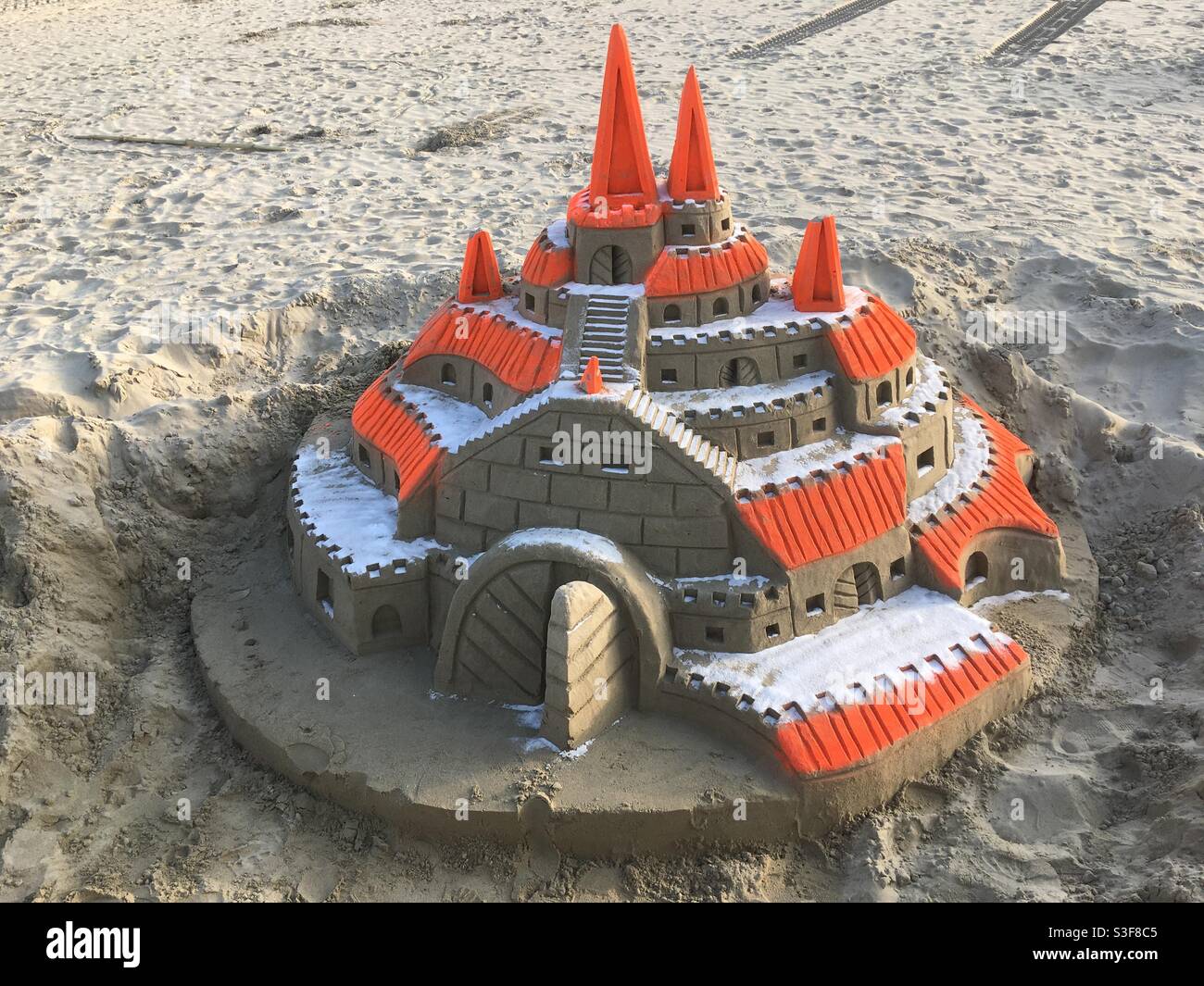Large orange and sand color sand castle on the beach in Palavas les Flots near Carnon plage and Montpellier, Occitanie, south of France - Smartphone Captured Stock Image