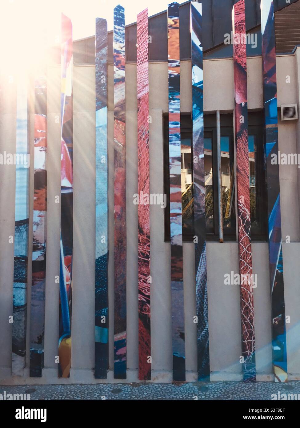 Vertical bars of different coloured patterns and textures on a building facade in Palavas les Flots near Carnon plage and Montpellier, Occitanie, south of France - Smartphone Captured Stock Image