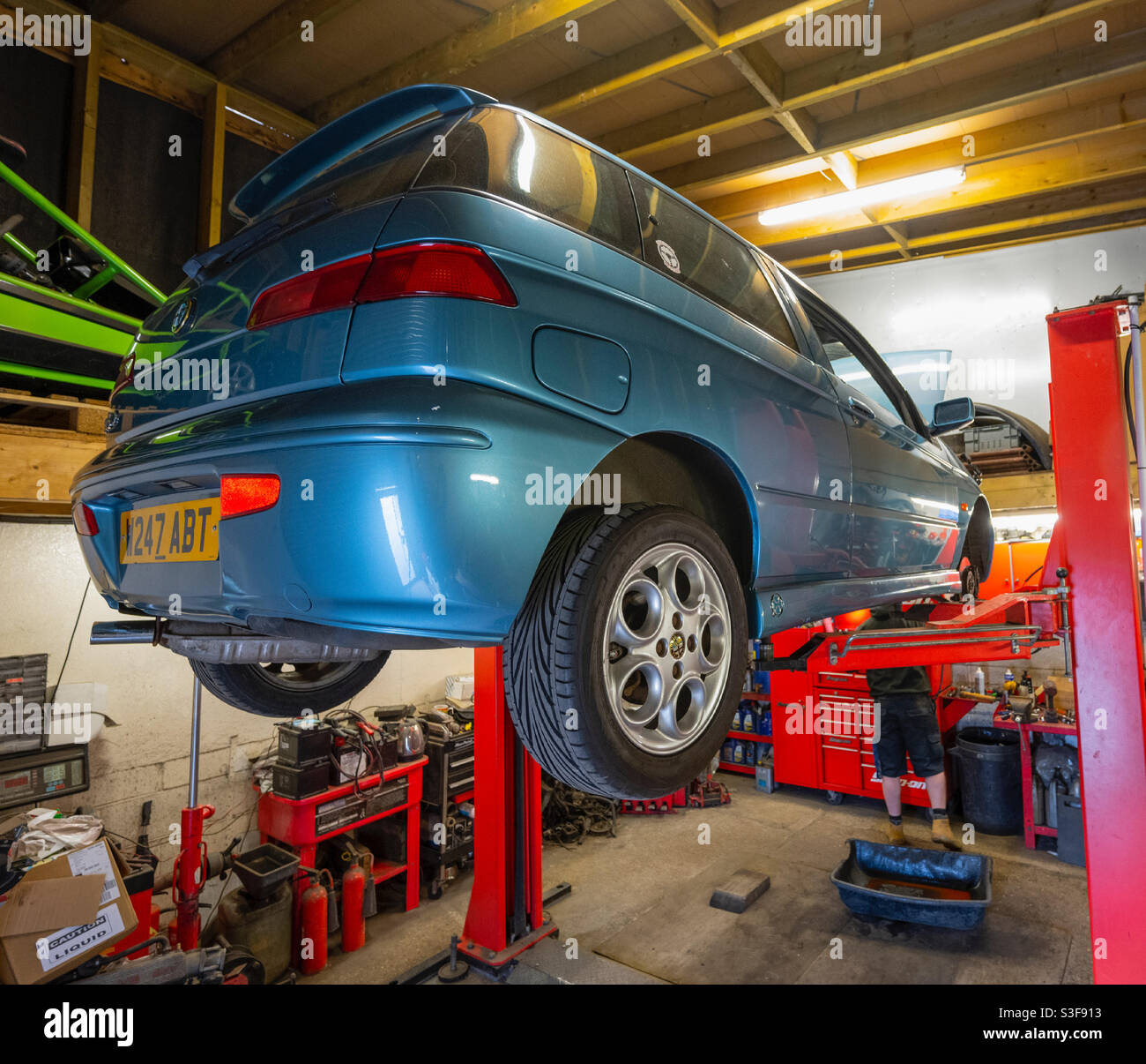 Car being serviced on a mechanic’s ramp (Alfa Romeo 145) - Smartphone Captured Stock Image