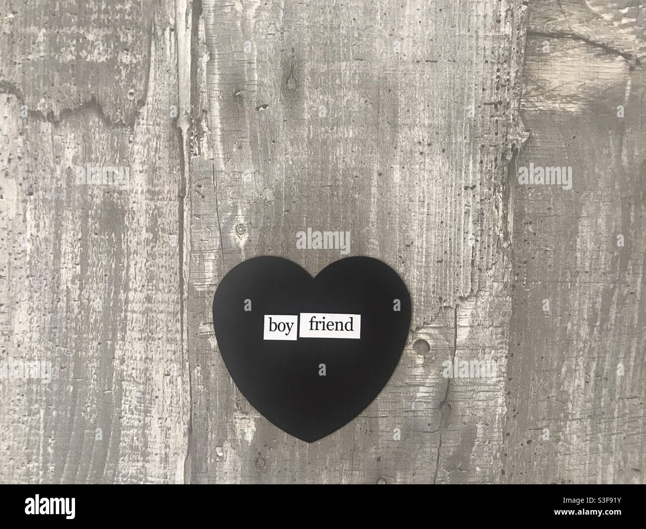 Boyfriend heart sign against a wooden background - Smartphone Captured Stock Image