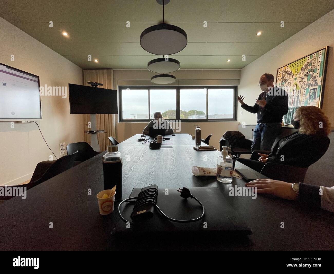 Four business men and women having a meeting in a conference room in Lunel, near Montpellier, Occitanie, south of France - Smartphone Captured Stock Image