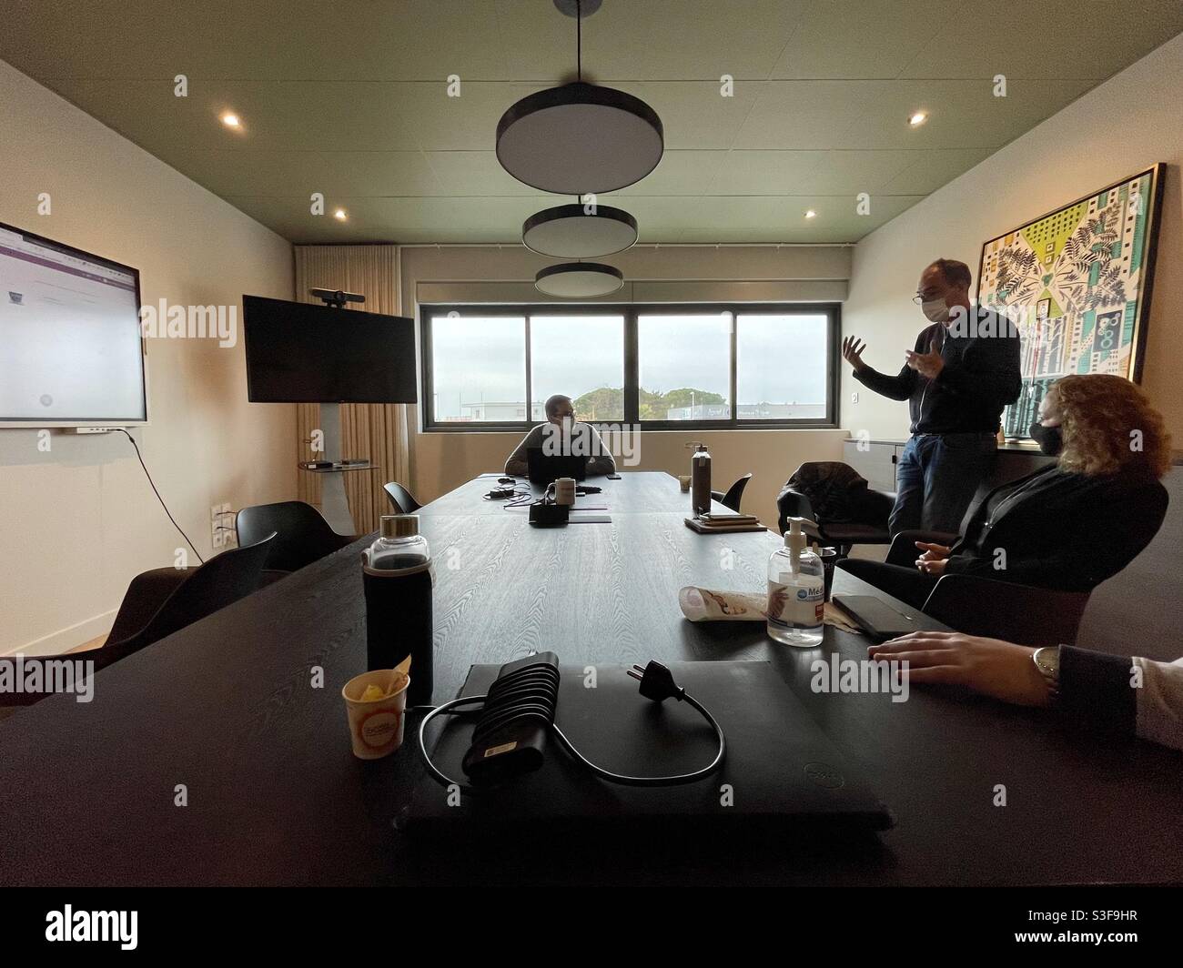 Four business men and women having a meeting in a conference room in Lunel, near Montpellier, Occitanie, south of France Stock Photo