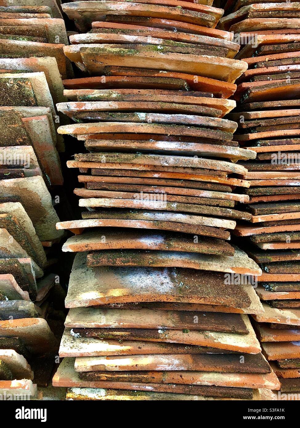Stack of old clay roofing tiles - France. - Smartphone Captured Stock Image