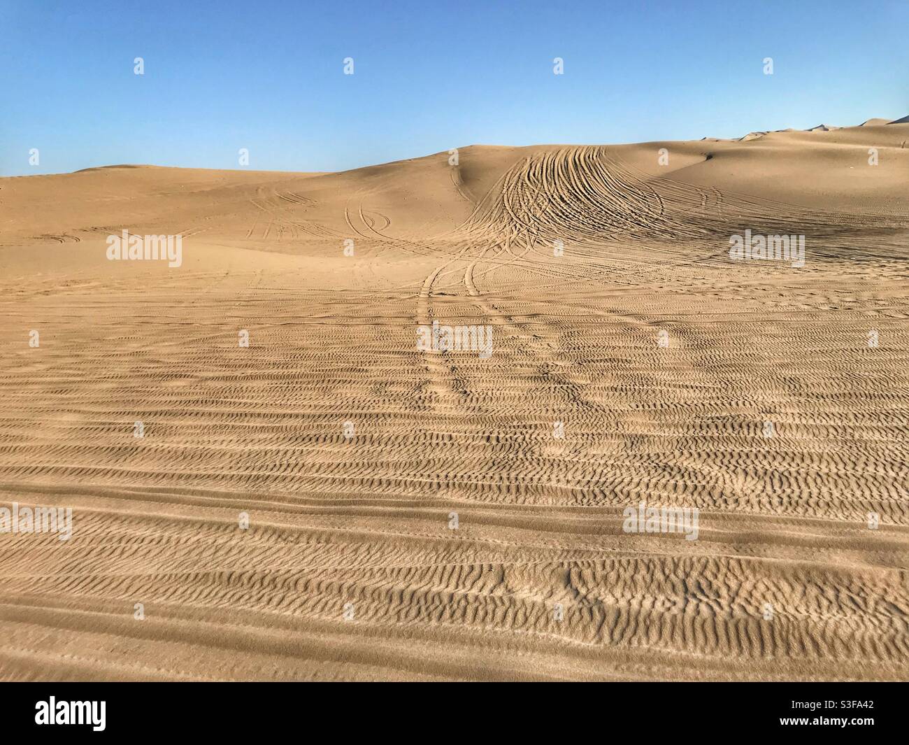 Dune buggy tire tracks in the desert in Huacachina, Peru - Smartphone Captured Stock Image