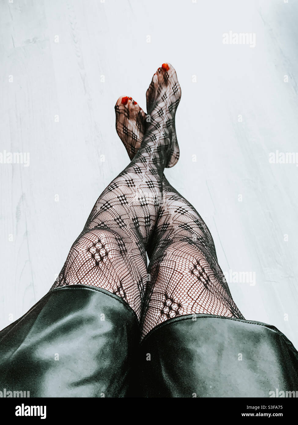 Woman wearing patterned tights and red painted toe nails Stock Photo