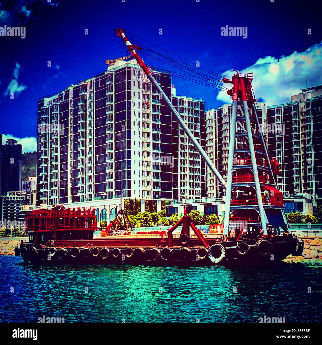 crane boat near the bank near a construction site in hong kong Stock Photo