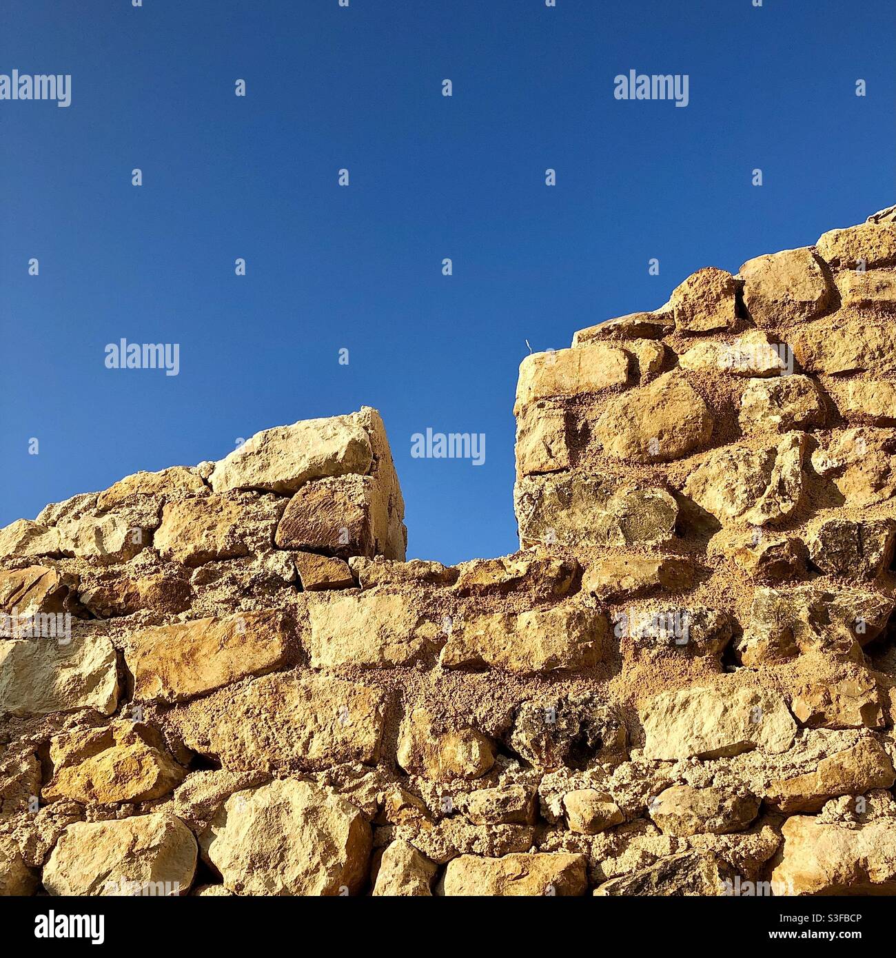 Old stone wall detail with roof removed. Stock Photo