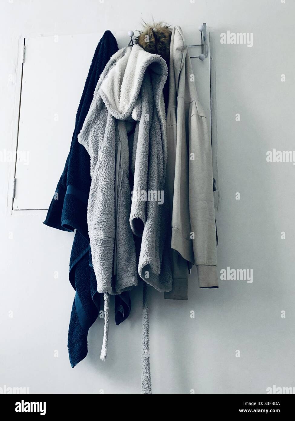 Towel, dressing gown, jackets hanging up Stock Photo
