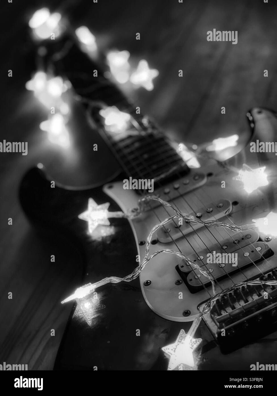 Old electric guitar with twinkle lights in black and white - Smartphone Captured Stock Image