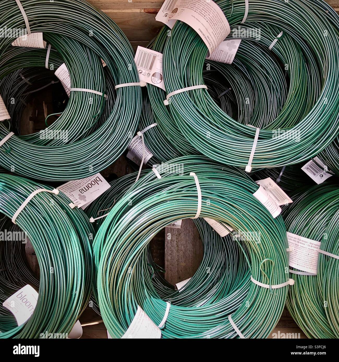 Display rack of rolls of plastic covered garden wire. Stock Photo
