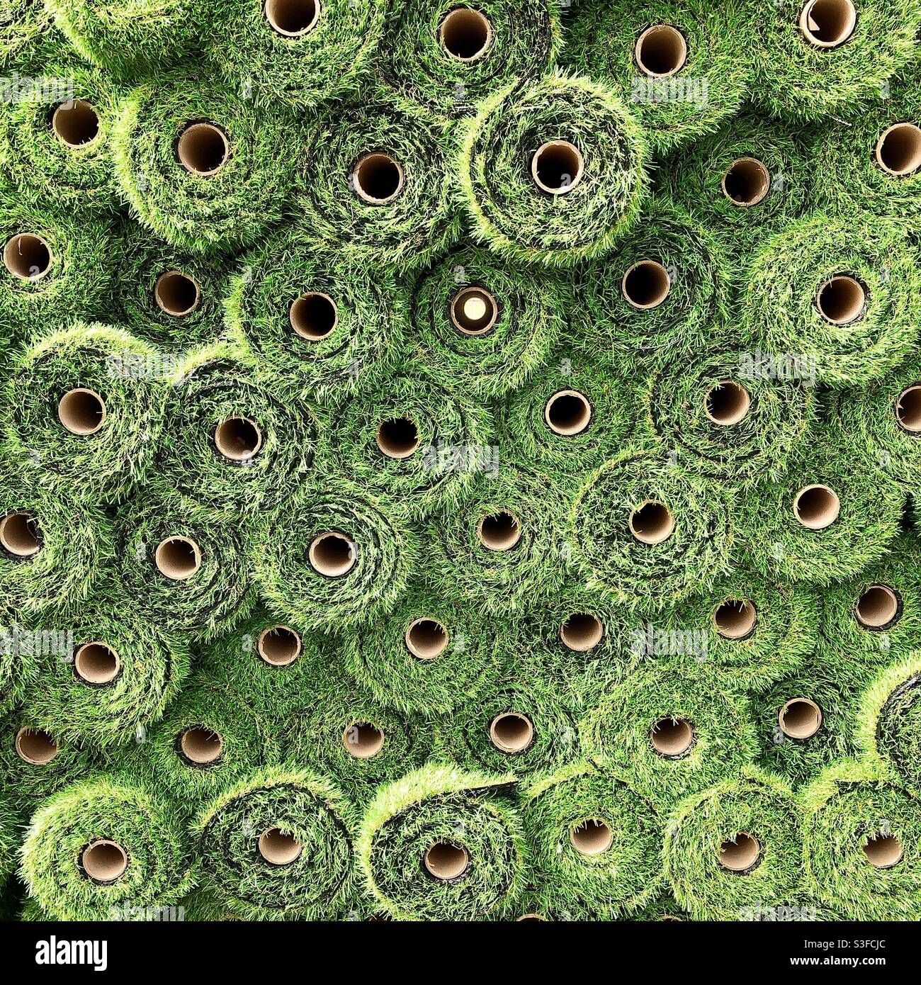 Stack of rolls of green plastic artificial grass matting. - Smartphone Captured Stock Image