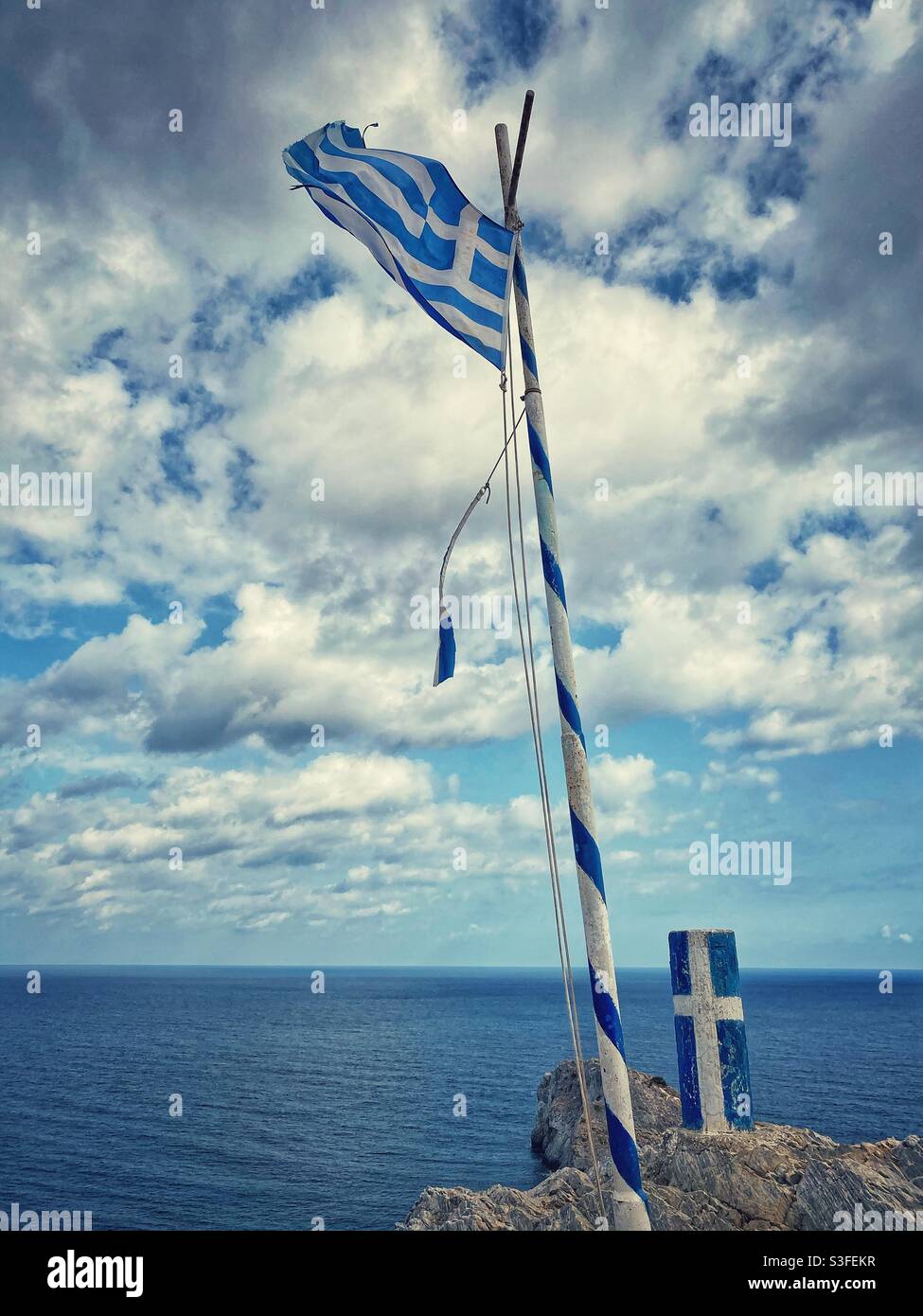 Greek flag with sea view at Kastro fortress on the North of Skiathos island. - Smartphone Captured Stock Image