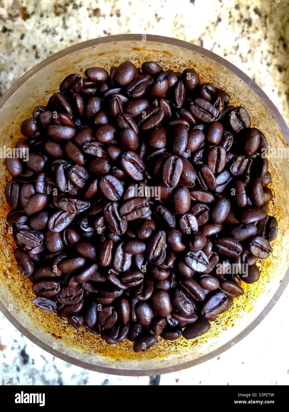 Rich, roasted, Arabica, espresso beans in a round bowl sitting on a granite counter. Fine coffee. Mostly grown in developing countries, it’s consumed mainly in developed countries. - Smartphone Captured Stock Image