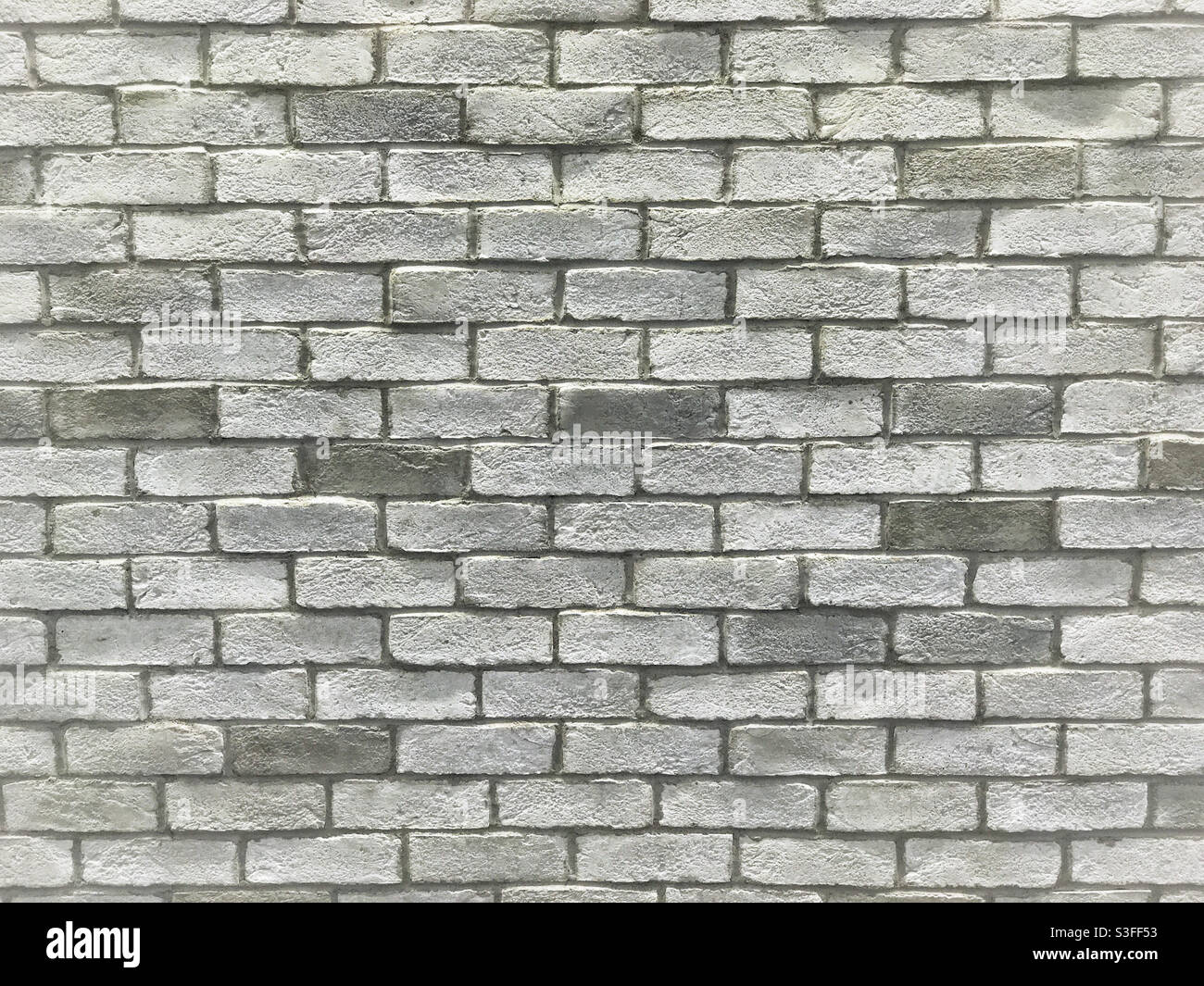 Uneven light-grey brick wall. Stock Photo
