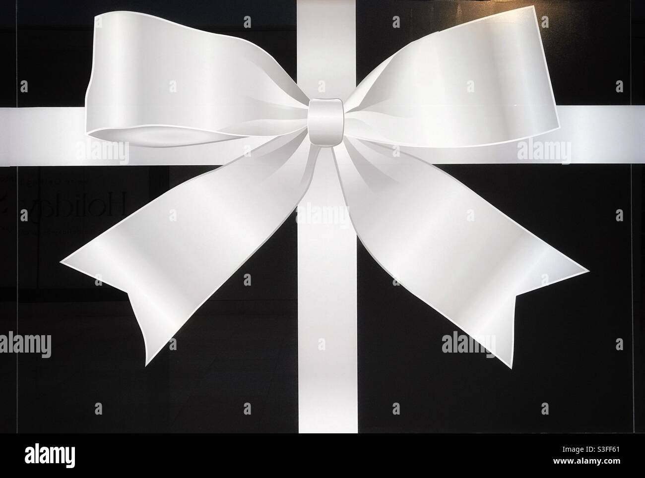 Large bow image covering the window of a new store under construction, in downtown Calgary, Alberta, Canada. - Smartphone Captured Stock Image