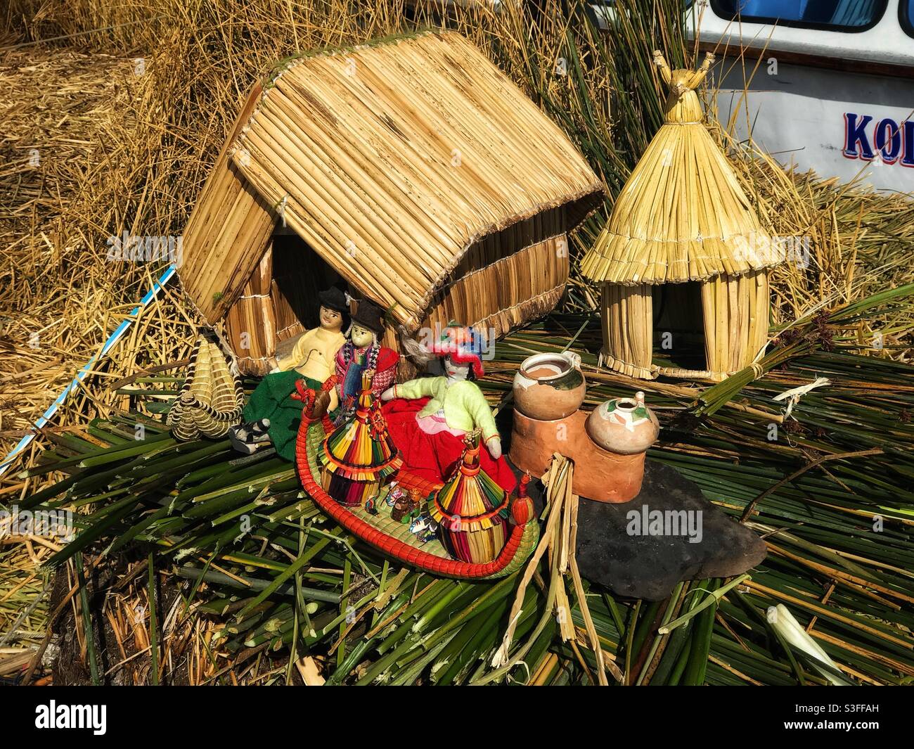 Models used as visual aids by a tour guide explaining how the floating islands of Uros in Lake Titicaca are made and how the inhabitants live - Smartphone Captured Stock Image